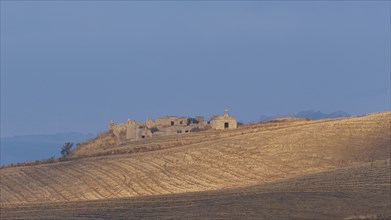 Dry hilly landscape, fields, farmstead, building, blue cloudy sky, Madonie National Park, autumn,