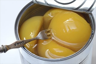 Peach, preserved peach halves with syrup in a tin can