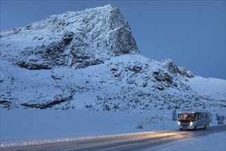 With motorhome in winter on Flakstadveien (E10) in front of the mountain Stortinden