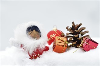 Christmas decoration, Inuit with Christmas tree ball and pine cones and Christmas presents lying in