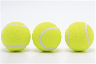 Sports equipment, three yellow tennis balls in a row