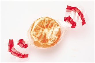 Wrapped fruit candy in the shape of an orange slice