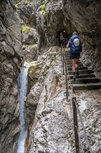 Hiker in a gorge, Hammersbach flows through Höllentalklamm, near Garmisch-Partenkirchen,