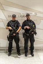 Two armed police officers on duty inside South Terminal, London Gatwick airport, England, UK