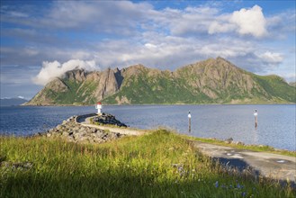 Lighthouse at harbour wall, fishing village Hovden, island Langoya, archipelago Vesteralen, Norway,