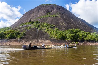 Fisherman with their fish before the huge granite hills, Cerros de Mavecure, Eastern Colombia