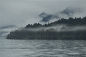 The westerly wind pushes the clouds against the steep slopes of the Chugach Mountains, the moisture