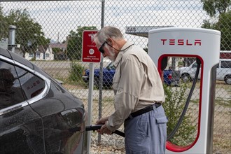 Poncha Springs, Colorado, A traveler plugs in his Tesla at a Tesla electric car charging station