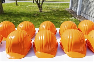 Orange-coloured safety helmets are on display for a factory tour