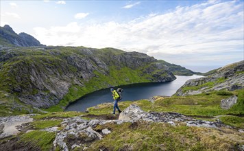 Climbers on a hiking trail, mountain landscape with lake Fjerddalsvatnet, Moskenesoya, Lofoten,