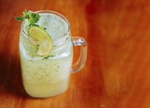 Refreshing lemonade with mint on wooden table. Lemonade drink on wooden table