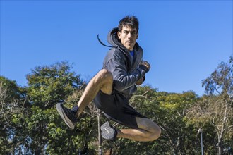 Martial arts fighter jumping in fly outdoors