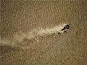 A tractor with a Horsch PRONTO DC 6 seed drill sowing in a dry field in late summer., Doma, Saxony,