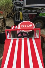 Stop sign in red and white striped soapbox at the Lafrowda Festival, St. Just in Penwith, Cornwall,