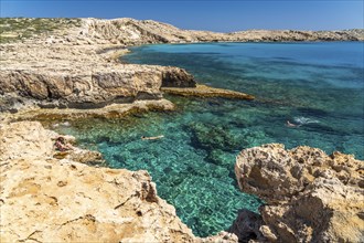 Tourists bathing in the crystal-clear turquoise waters of the Cape Greco peninsula, Agia Napa,