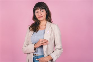 Beautiful woman wearing a pink breast cancer awareness ribbon while showing it