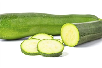 Courgettes (Cucurbita pepo), whole and cut, on white