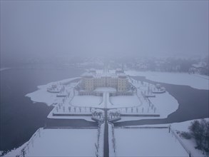 Snowfall over Moritzburg Castle on its distinctive pond island