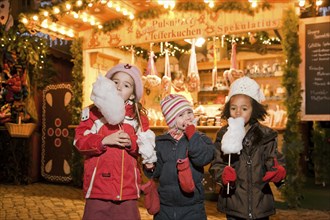 Children eat candy floss at the Striezelmarkt in Dresden