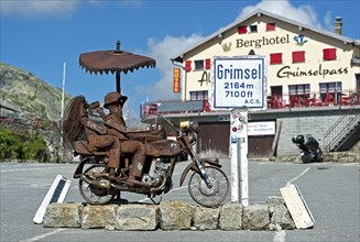 Biker couple, metal sculpture on the Grimsel Pass in front of the Berghotel Alpenlodge Grimselpass,