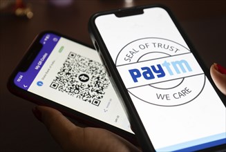 In this photo illustration, the Paytm logo and PhonePe QR code, is seen displayed on mobile phones