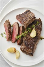 Overhead view of beef strip steak medium rare on a plate