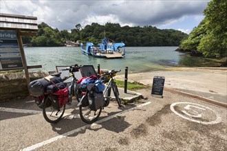 Two e-bikes, touring bikes at the King Harry Floating Bridge jetty, chain ferry on River Fal,