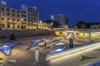 Modern architecture and colourfully lit fountains of Eleftheria Square at dusk, Nicosia, Cyprus,