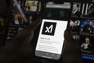 In this photo illustration, A person browses website of xAI, displayed on a mobile phone, Elon Musk