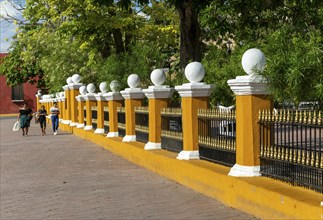 Three women walking along side of main zocalo park in city centre, Valladolid, Yucatan, Mexico,