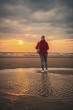 Tourist on the beach at sunset, Zandvoort, Netherlands