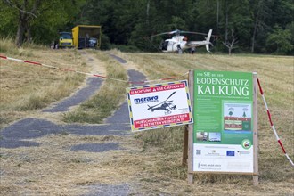 Signs for soil protection liming at a cordoned-off helicopter landing site, forest edge,