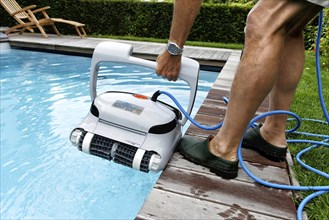 Cleaning robot ensures clear water and cleanliness in private swimming pool, Germany, Europe