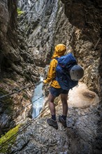 Hiker in a gorge, Hammersbach flows through Höllentalklamm, near Garmisch-Partenkirchen,