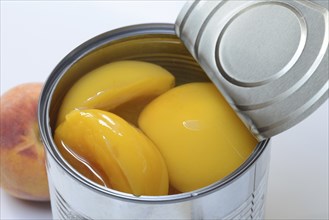 Peach, preserved peach halves with syrup in a tin can