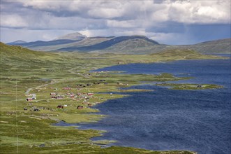 Road and red houses by a large lake, Fjell, barren mountain landscape, Oystre Slidre, Jotunheimen