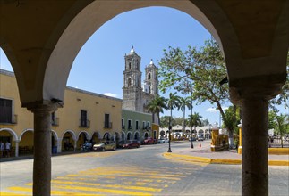 View to church from colonnaded walkway on main square, Spanish colonial architecture, Valladolid,