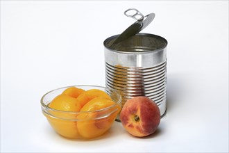 Peach, pickled peach halves in glass bowl and tin can