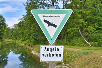 German sign for German Nature Reserve and no fishing sign in front of river