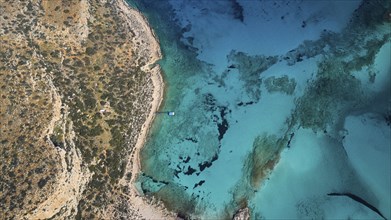 Drone shot, aerial view of a rocky coast with turquoise water and a small jetty, Gramvoussa,