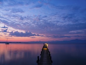 Sailing boat and jetty on Lake Chiemsee at dawn, behind the Chiemgau Alps, Chiemgau, Upper Bavaria,