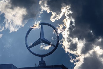 Symbolic image, Dark clouds at Mercedes, Mercedes logo on a building surrounded by dramatic cloud