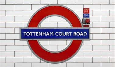 Tottenham Court Road sign on the London Underground against a background of white tiles with a red