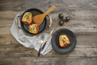 Overhead view of roasted bell peppers stuffed with goat cheese and mozzarella on wooden table