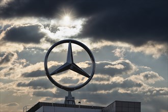 Symbolic image, Dark clouds at Mercedes, Mercedes logo on a building surrounded by dramatic cloud