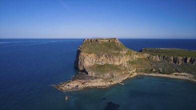 Drone shot, Rocky cliff coast with neighbouring beach and clear blue sky over the wide ocean,