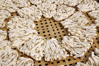 Handmade ribbon noodles dry in the sun at a noodle manufacturer in Taiwan