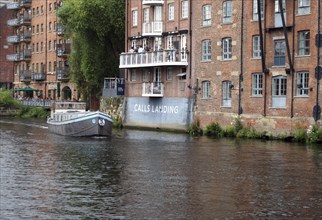 Leeds, west yorkshire, united kingdom: 16 july 2019: a boat sailing past calls laning in the river