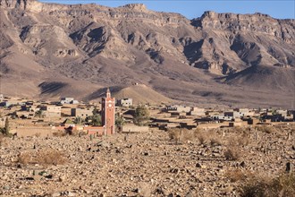 A semi deserted barbarian village in the atlas mountains surrounded by date palms along the road