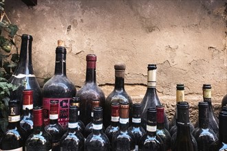 Old open red wine bottles dusted by time. Chianti, Brunello di Montalcino e Vino Nobile di